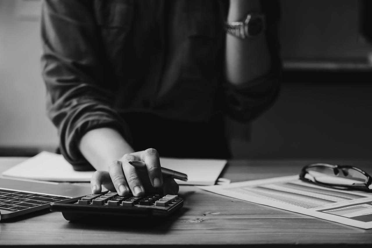 Hand with calculator and pencil Business woman entrepreneur using a calculator with a pen in her hand, calculating financial expense