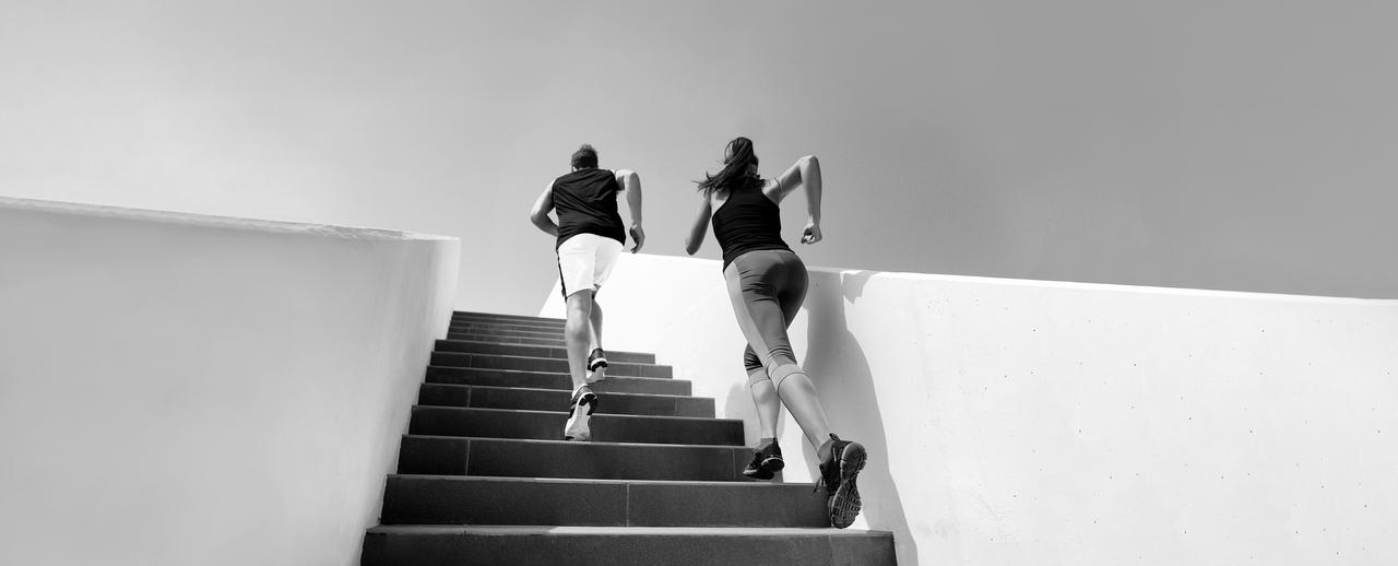 Two runners or athletes on a staircase Runners running up steps and working out